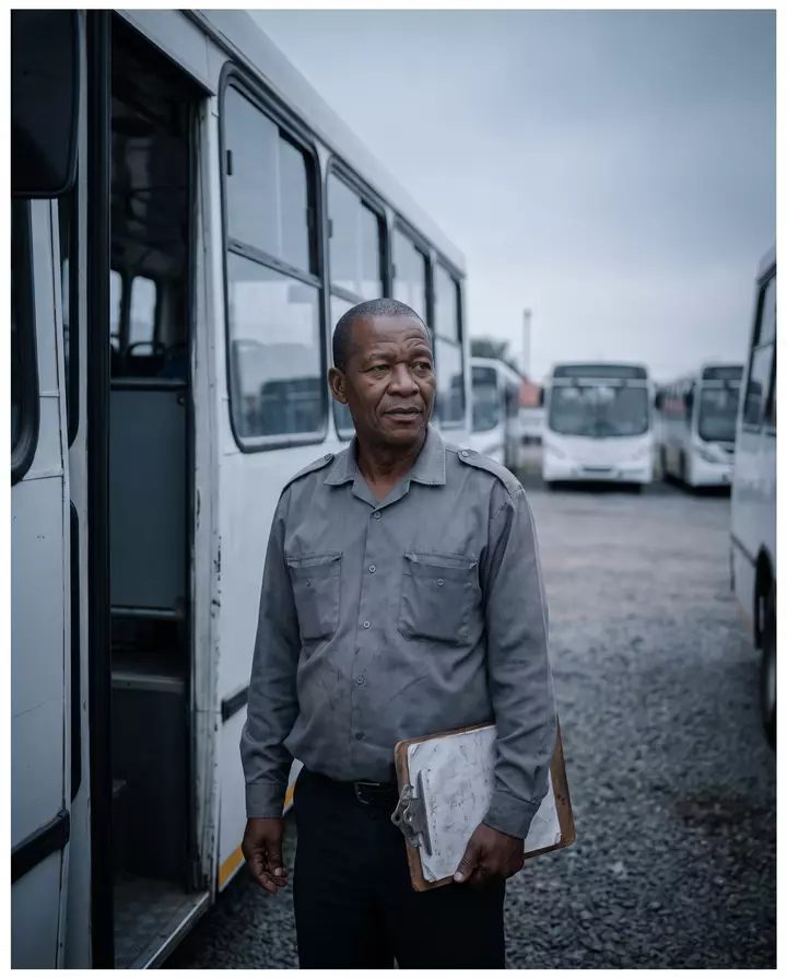 A bus driver with a clipboard at a depot